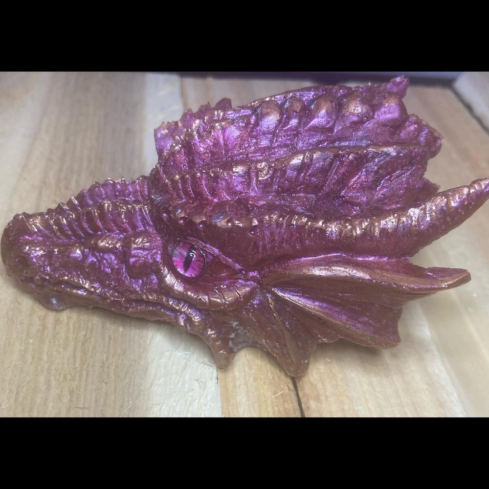 I am selling a dragon head. It is a pink/purple color, and has a gold affect.